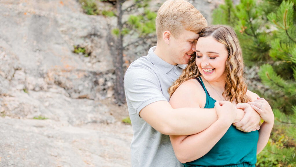 Engaged couple hugging in Sylvan Lake, Custer, South Dakota