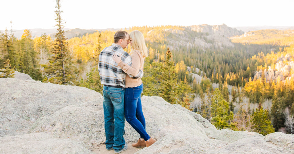 Engaged couple looking at each other standing in Black Elk Peak, Custer, South Dakota