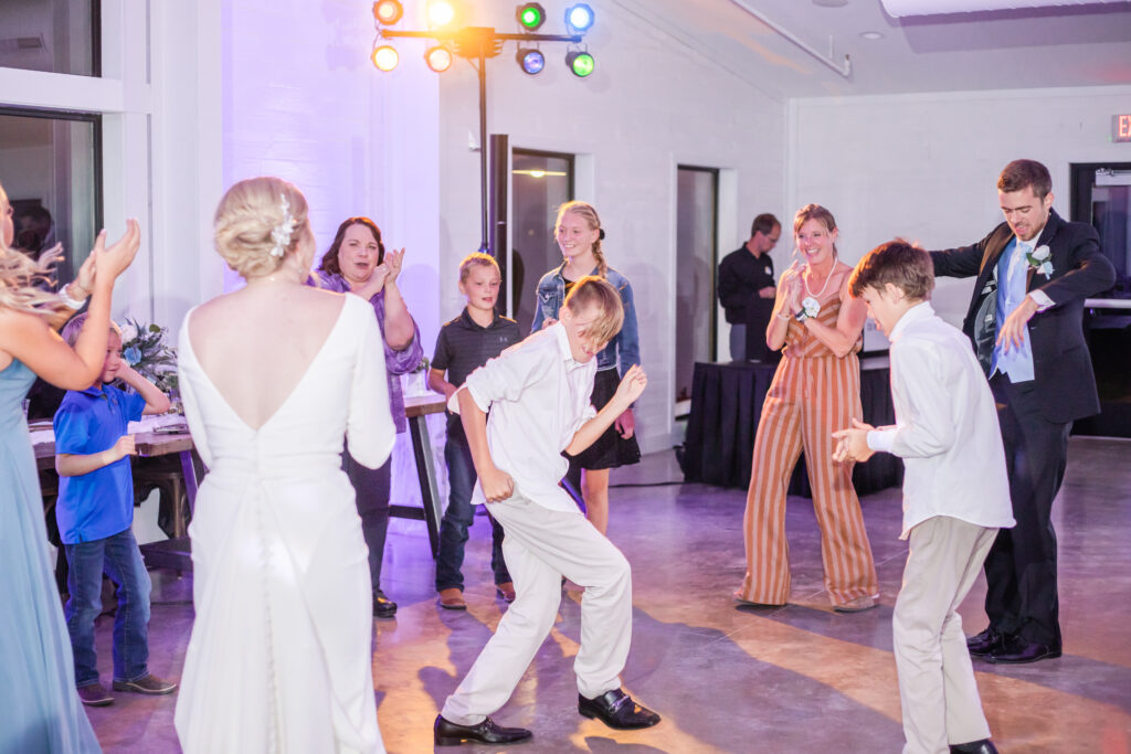 wedding party dancing photo with boy dancing in the middle of group