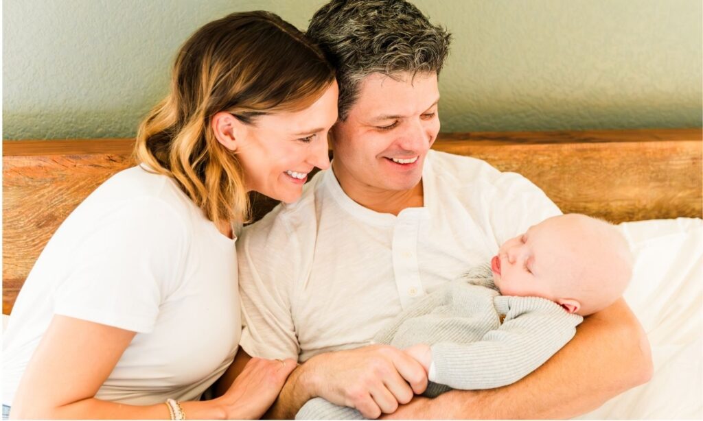 mom and dad smile at their new blessing in the black hills while capturing the newborn bliss moments.
