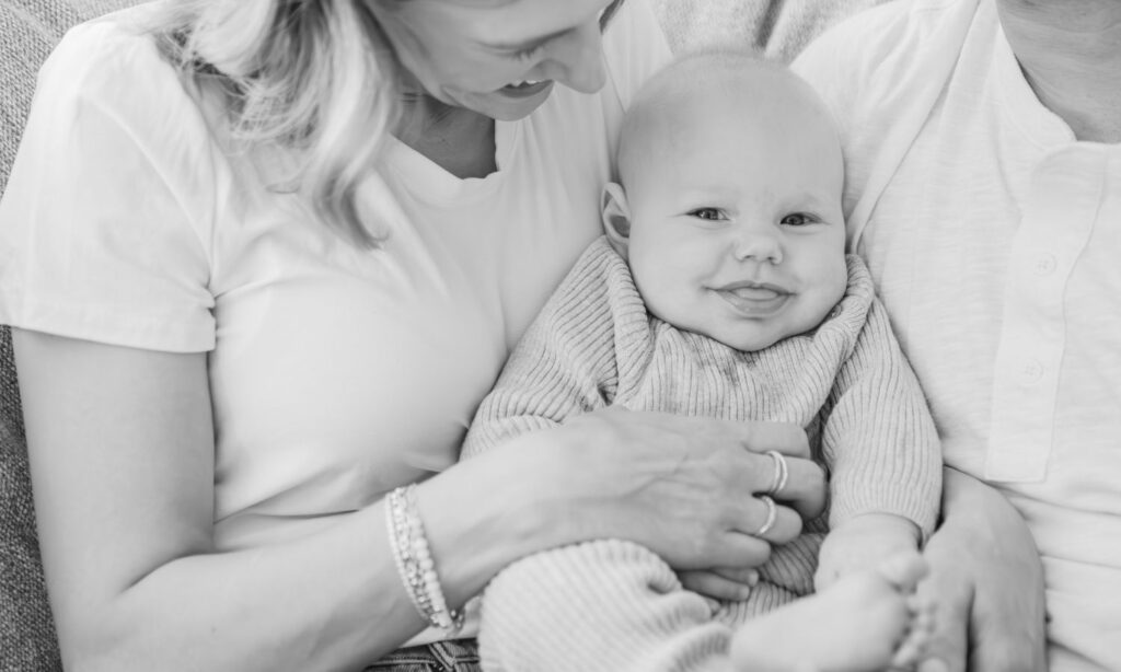 a sweet newborn baby smile and mom smiling down at him in the black hills sunlight.